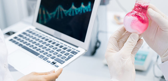 DNA double-helix on laptop screen with scientists' hands